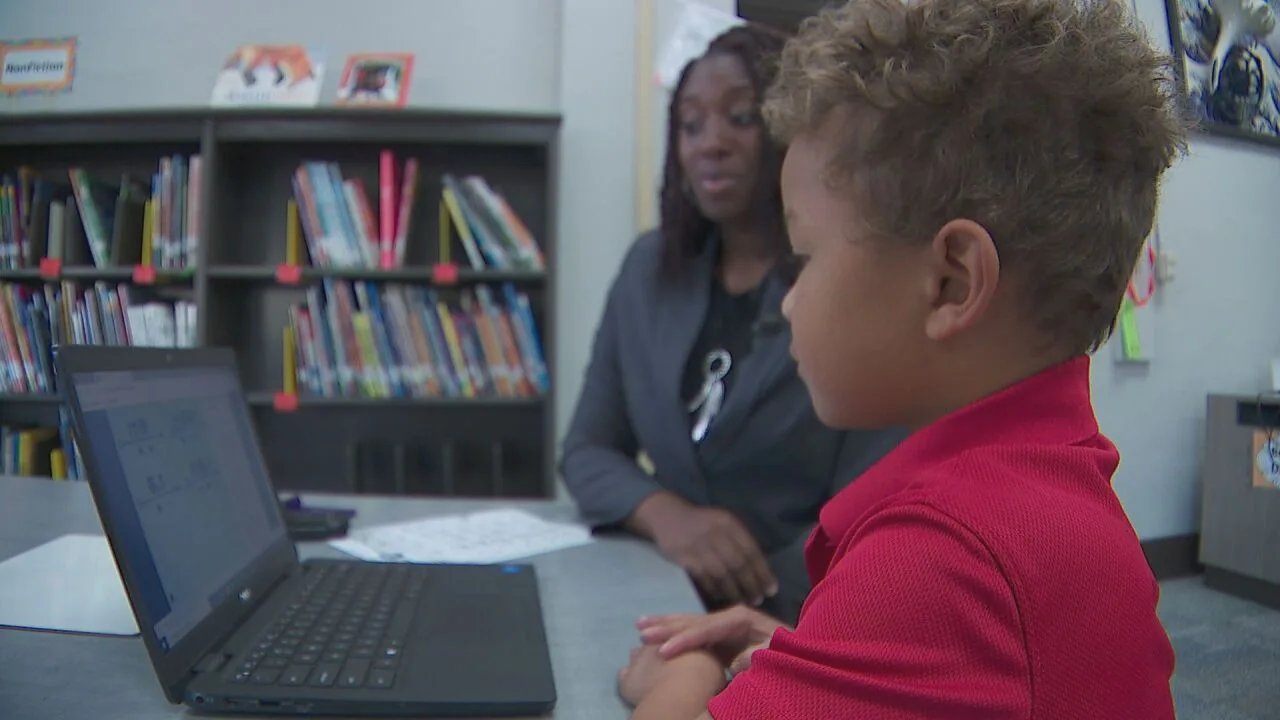 An instructor working one-on-one with a student on a laptop